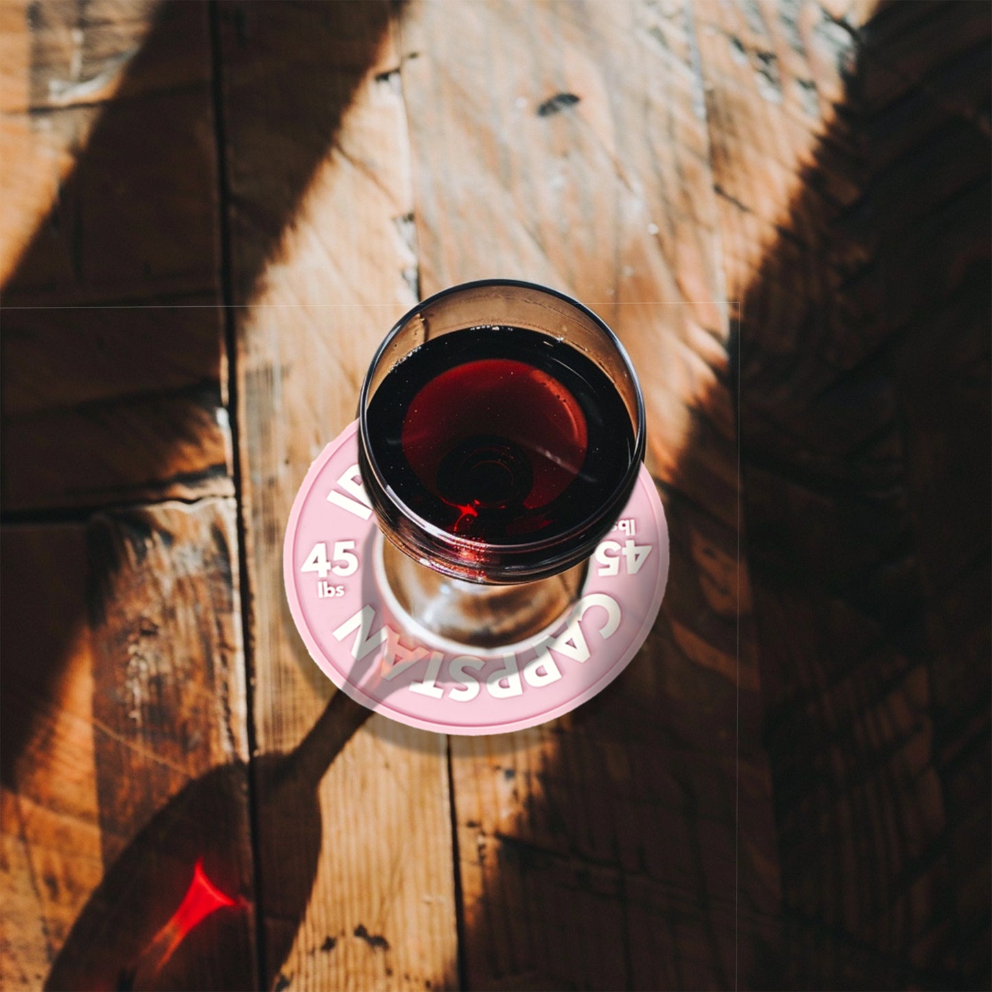 This image shows a pink coaster with an AI generated image of a glass of wine.