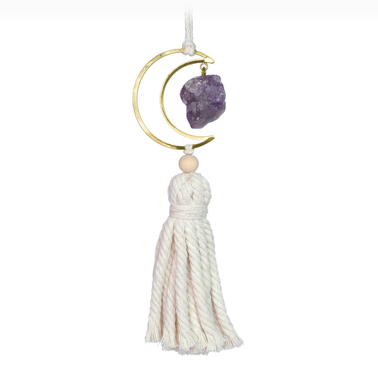 Picture shows an purple amethyst crystal hanging from a gold crescent. Underneath is a white jute tassel